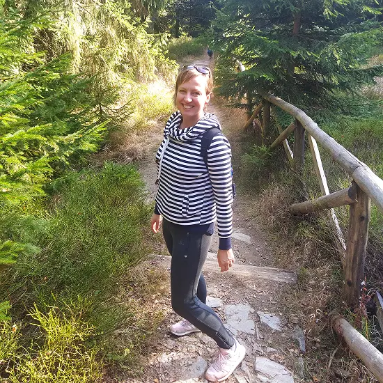 Lucie stojí v přírodě a usmívá se